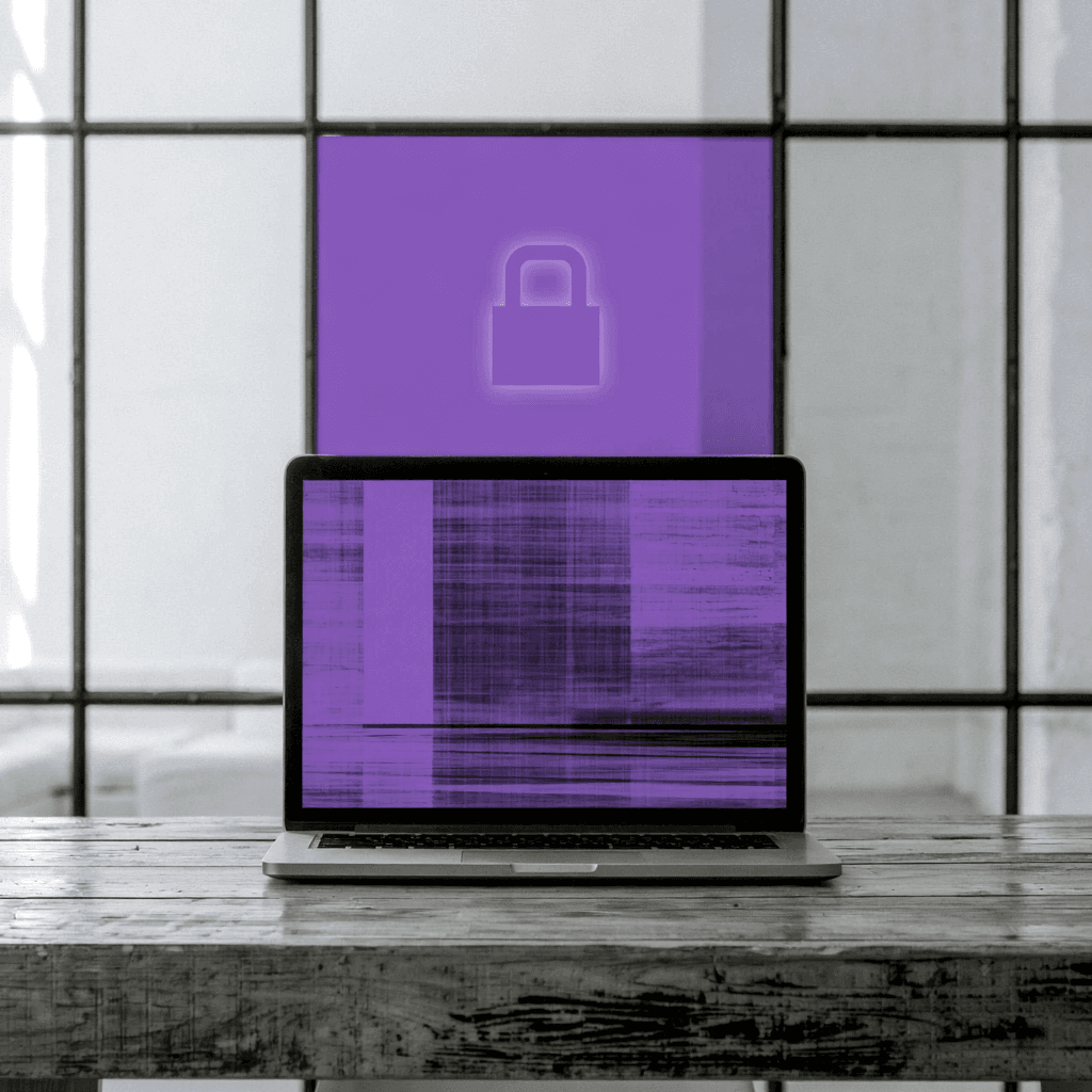 Ordinateur portable sur une table en bois, cadenas violet symbolisant la protection des données